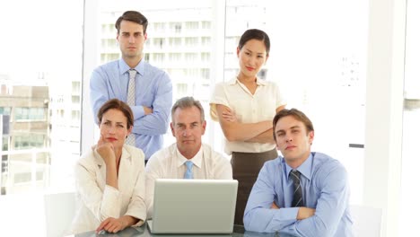 equipo de negocios serio posando frente a la computadora portátil