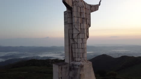 drone ascending, revealing a concrete statue of jesus