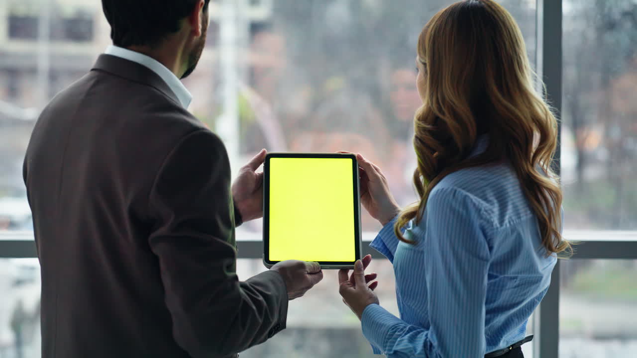 Business partners holding mockup tablet browsing project standing office closeup
