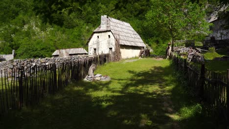 traditional stone house and wooden fence on green landscape of mountains in albania