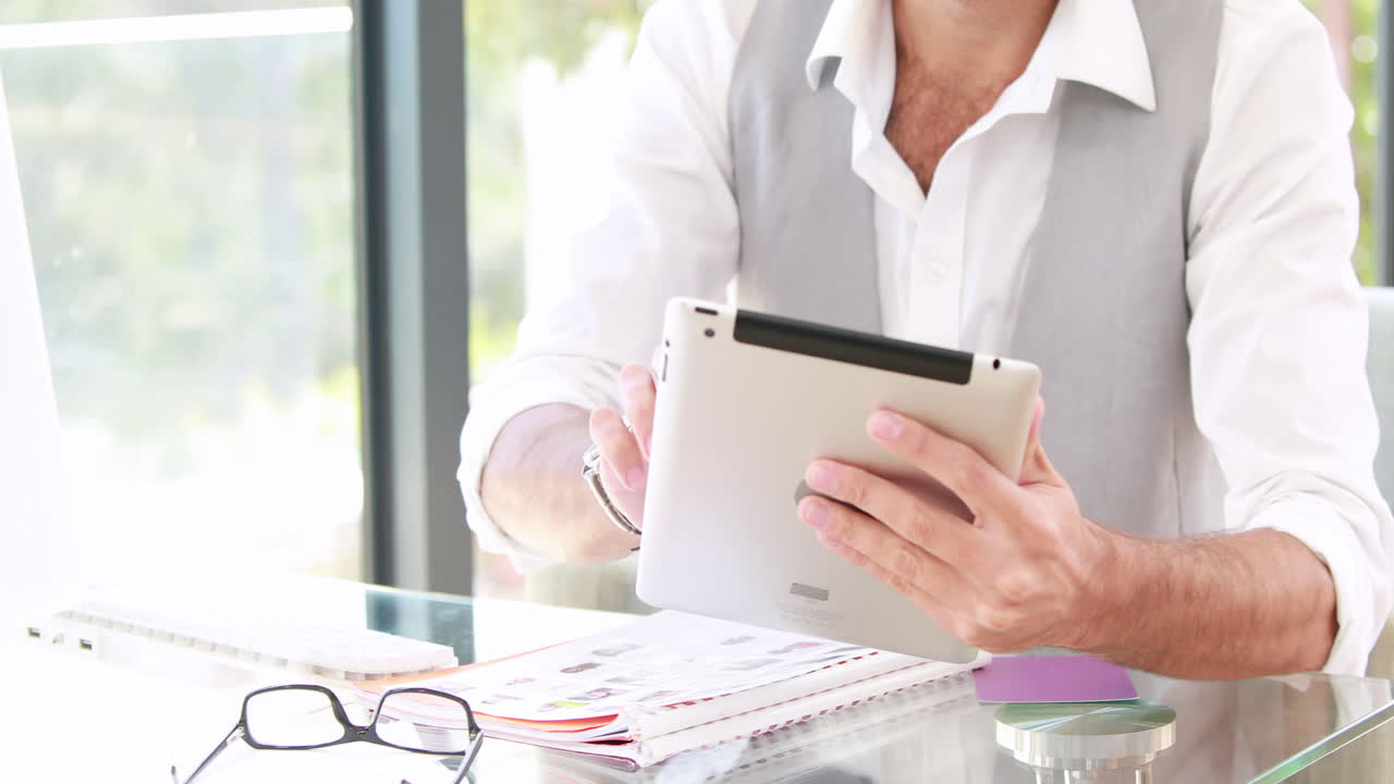 un empresario hipster sonriente usando su tableta