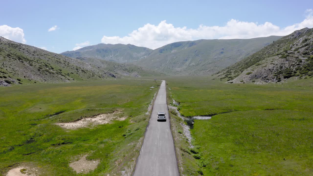 좁은 직선으로 흰색 차를 따라가는 드론