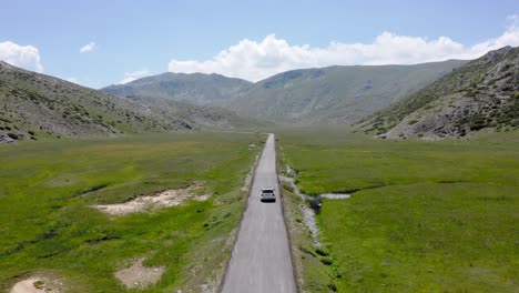 drone following a white car in narrow straight