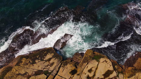 Vista-Superior-De-Múltiples-Olas-Oceánicas-Azules-Y-Verdes-Que-Se-Estrellan-Contra-La-Costa-Rocosa-En-Australia