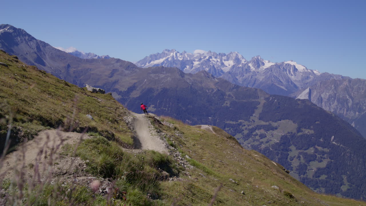 Man riding downhill mountain bike in Verbier during a stunning sunset, surrounded by epic alpine landscapes and golden mountain light.