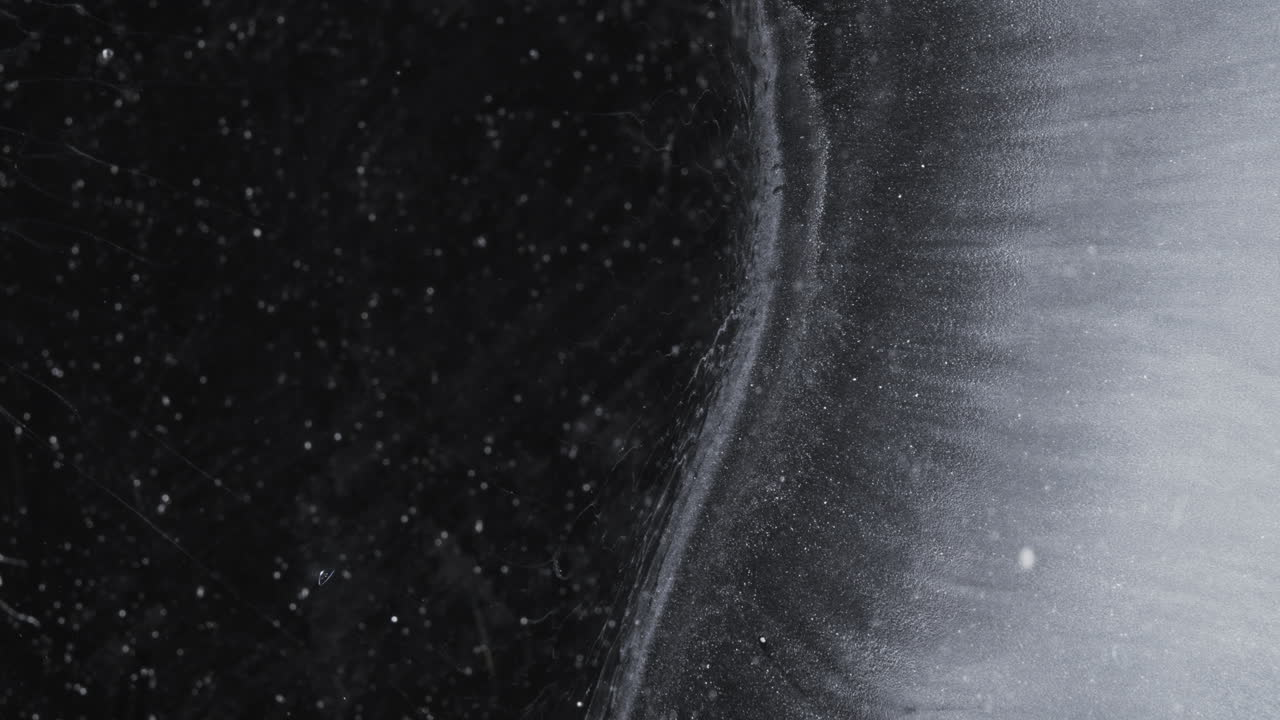 Abstract ink patterns mixing in macro view, showcasing fluid movement and color