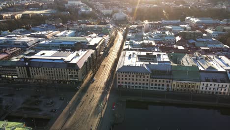 Early-Morning-View-With-Bright-Sun-Rays-Above-The-Buildings-And-Old-Street-In-Brunnsparken,-Hamngatan-In-Gothenburg,-Sweden---Aerial-Drone-Shot