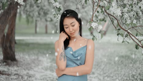 woman in a blue dress under a blooming tree