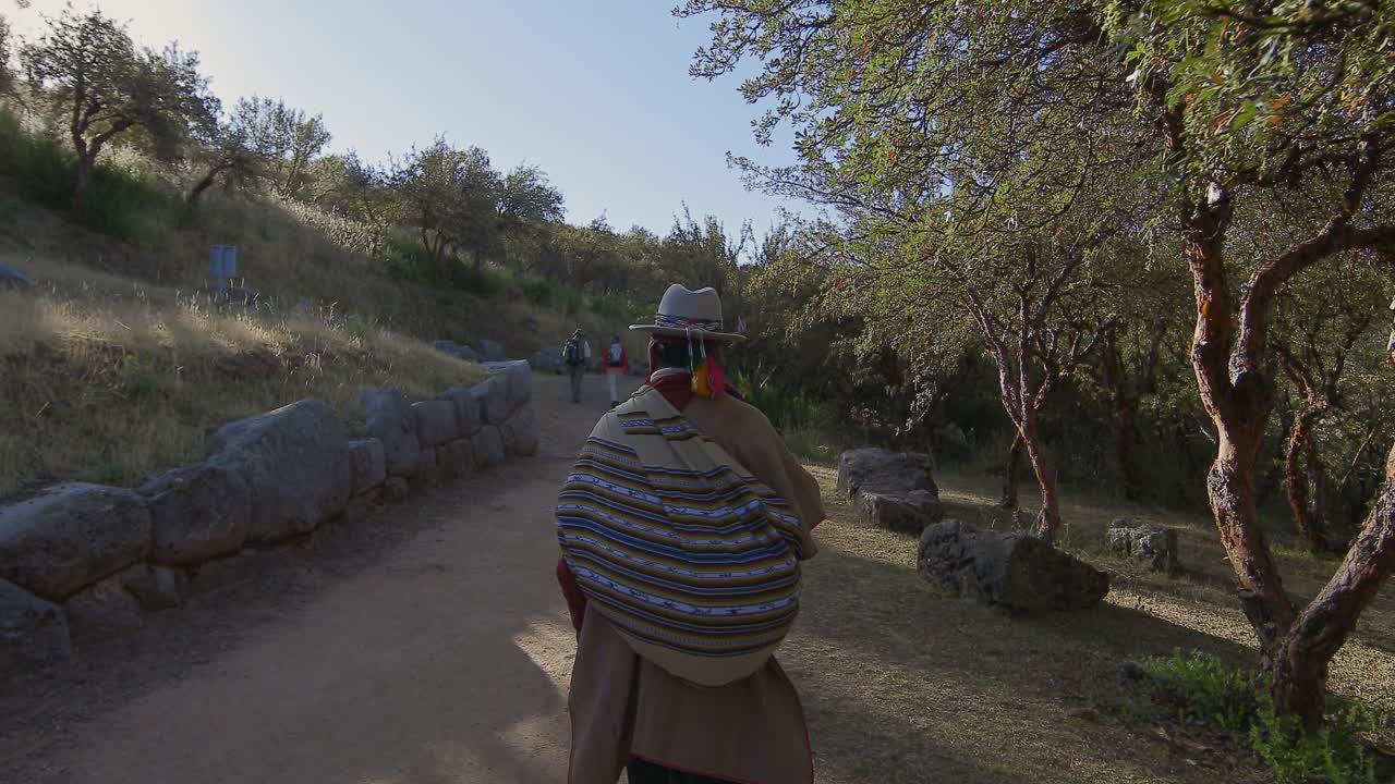 chamán caminando por un camino rural en perú