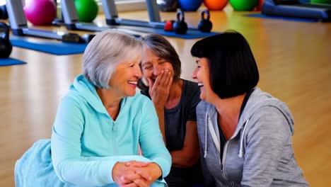 senior women laughing and resting at the gym after a workout.