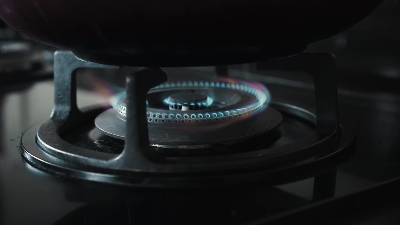 부에서 파란색과 빨간색으로 불타는 불꽃이 있는 검은색 가스 스토브의 비디오