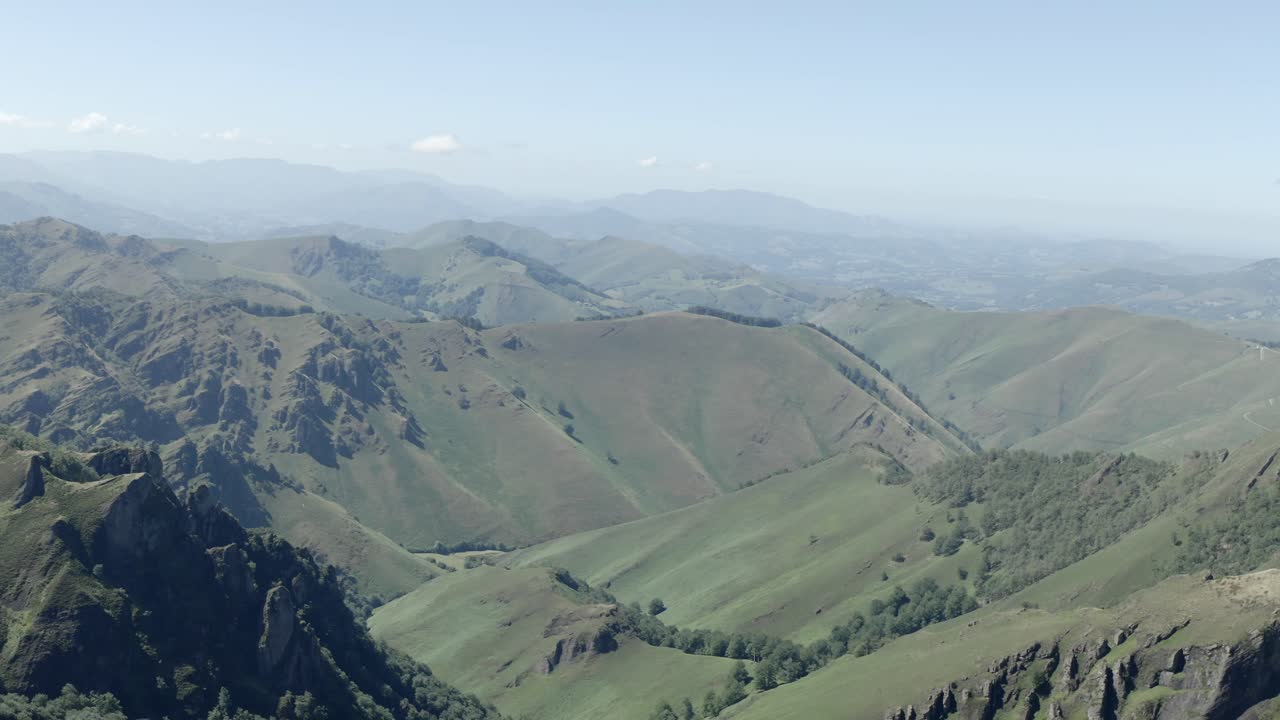 Aerial view of breathtaking rolling green mountain landscape under clear summer sky at Col de Sourzay, Lecumberry, France