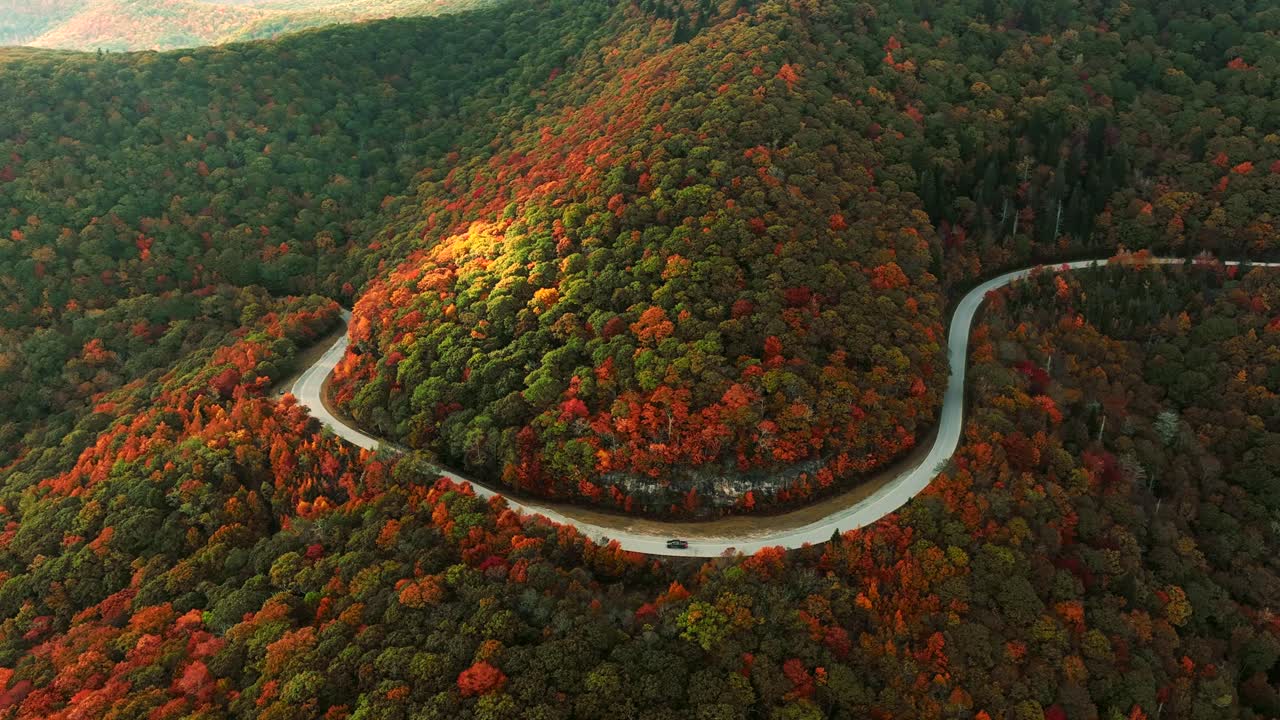 가을에 산  ⁇ 에 휘어지는 도로를 따라 트럭을 따라 느린 팬
