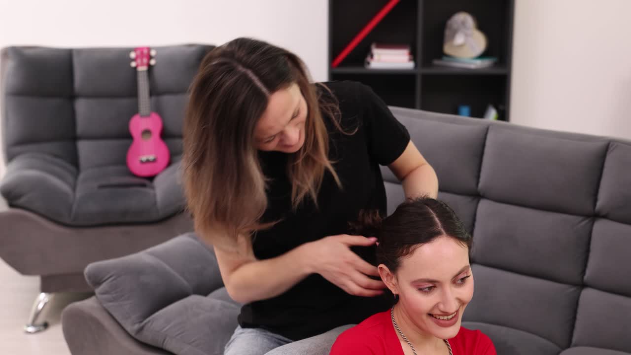 A woman styling another woman's hair