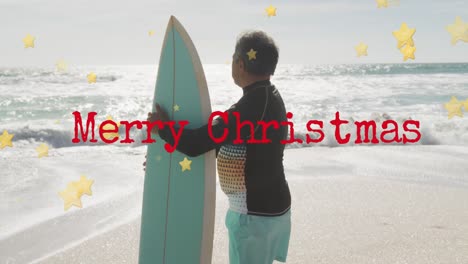 Animation-of-merry-christmas-text-over-senior-biracial-man-at-beach