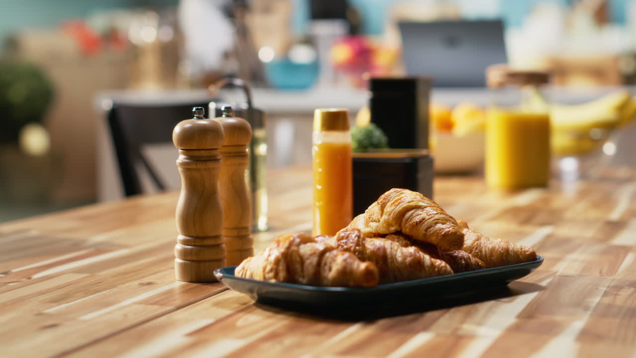 Empty kitchen table with croissants and homemade food for breakfast