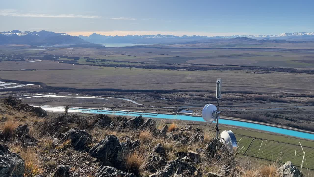 vista de alto ángulo de un canal hidroeléctrico y montañas cubiertas de nieve en nueva zelanda