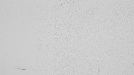 clear viscous fluid with tiny bubbles against white backdrop