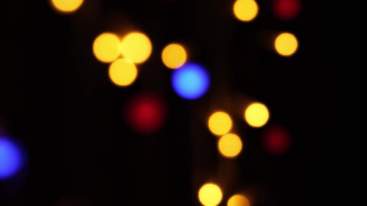 fondo bokeh abstracto en movimiento. brillantes, borrosas partículas multicolores, luces. bokeh brillante de guirnaldas en fondo oscuro. telón de fondo festivo de año nuevo o navidad