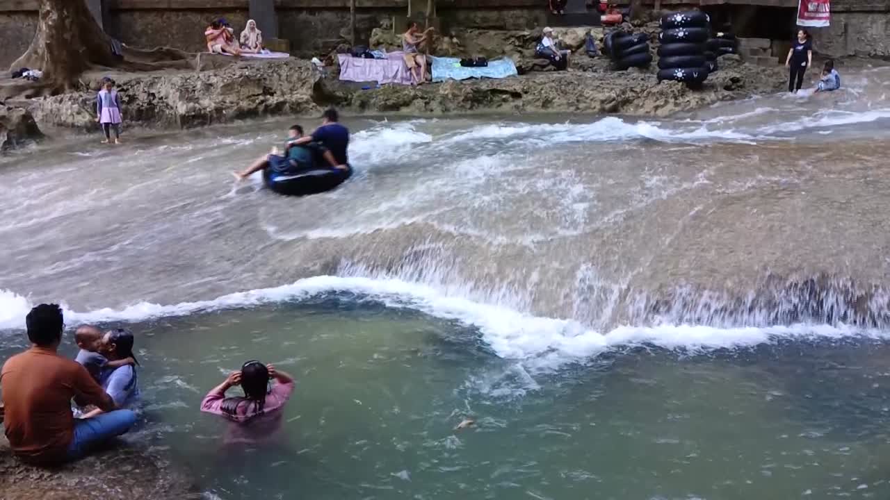 People enjoying tubing and swimming in a river