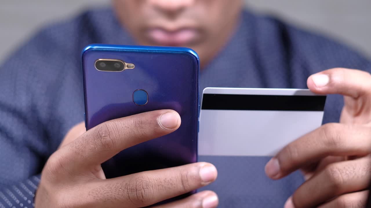 persona que hace un pago móvil con una tarjeta de crédito