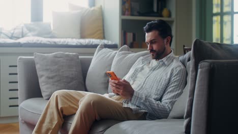 man using smartphone on a couch