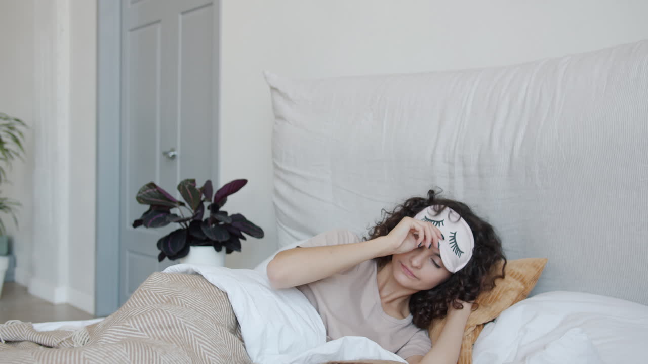 mujer durmiendo en la cama con una máscara para dormir