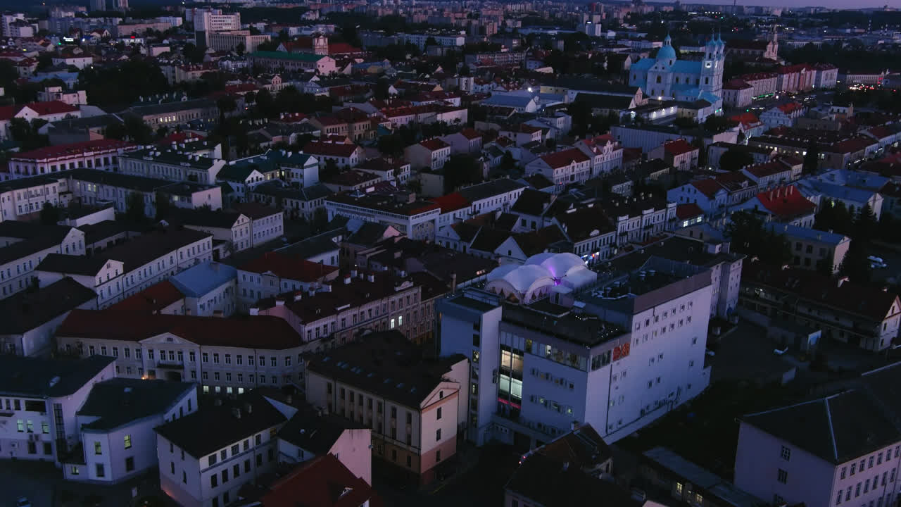 Ripresa aerea con drone sulla città di Grodno al tramonto, con chiesa e cattedrale, tetti storici e skyline serale in Bielorussia.