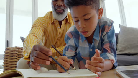 front view of mature black father helping his son with homework in a comfortable home 4k