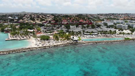 jan thiel beach with clear turquoise water in curacao, luxury resort area, aerial view