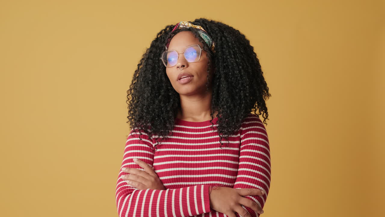 Thoughtful Young Black Woman with Curly Hair and Glasses