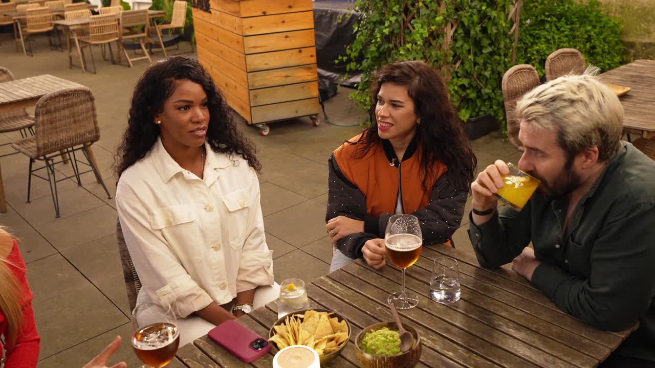 People enjoying food and drinks at an outdoor restaurant table