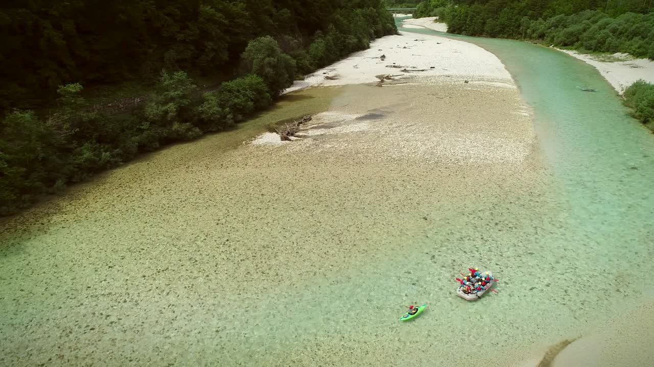 소카 강 (soca river) 의 푸른 물에서 래프팅을 하는 래프터 그룹의 공중 사진.