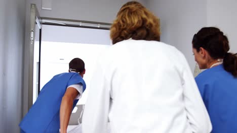 doctors pushing emergency stretcher bed in corridor