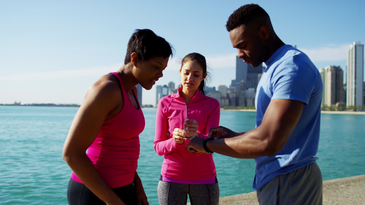 personas multiétnicas descansando y comprobando el reloj inteligente