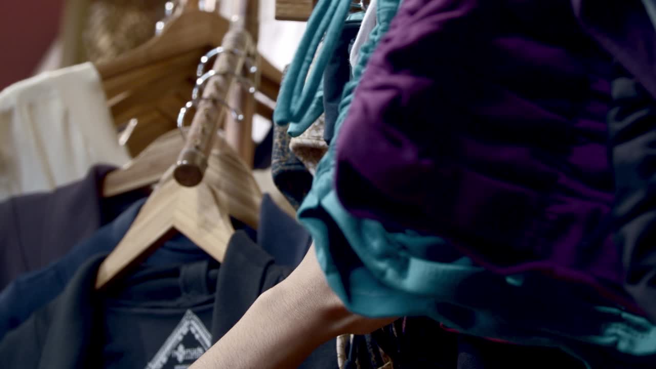 buscando a mano en el estante de ropa