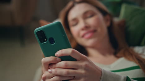 relaxing woman typing sms holding smartphone at home couch closeup. lady texting