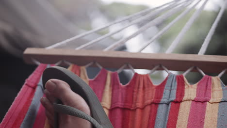 POV-Of-Foot-On-Hammock-At-Camping-Site-Wearing-Flip-Flops,-SLOW-MOTION