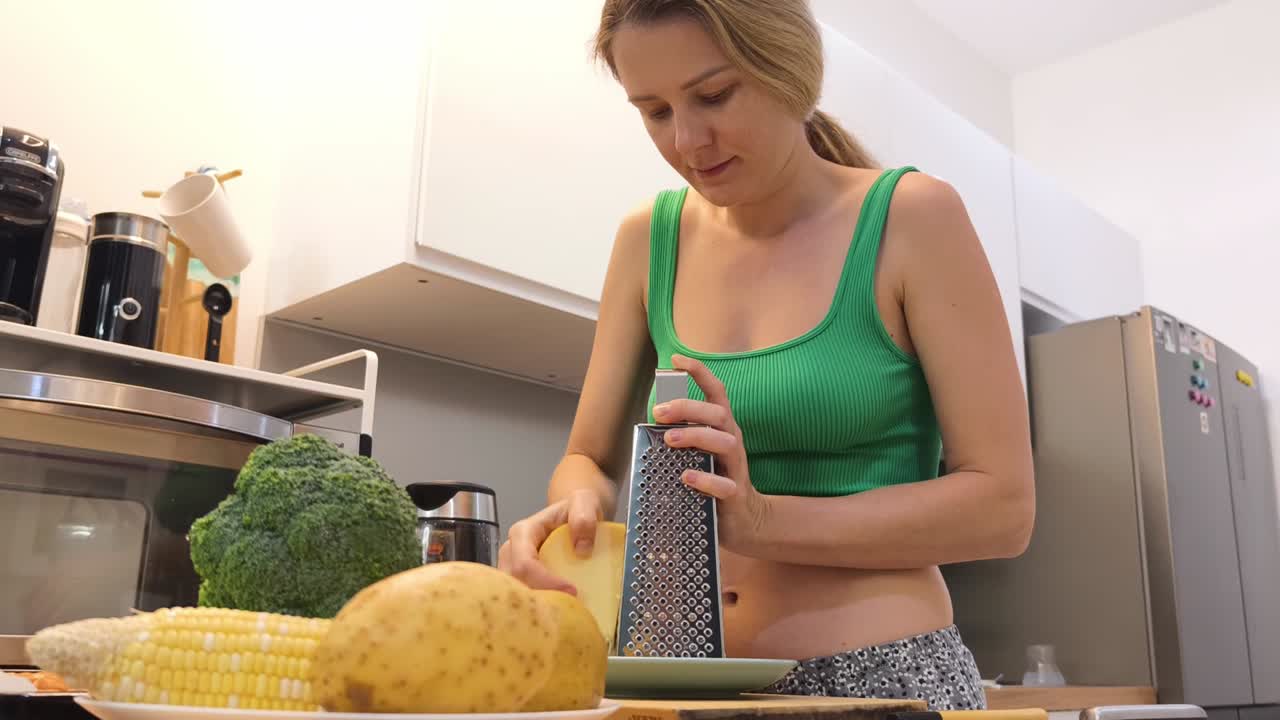 Donna che grattugia il formaggio in cucina