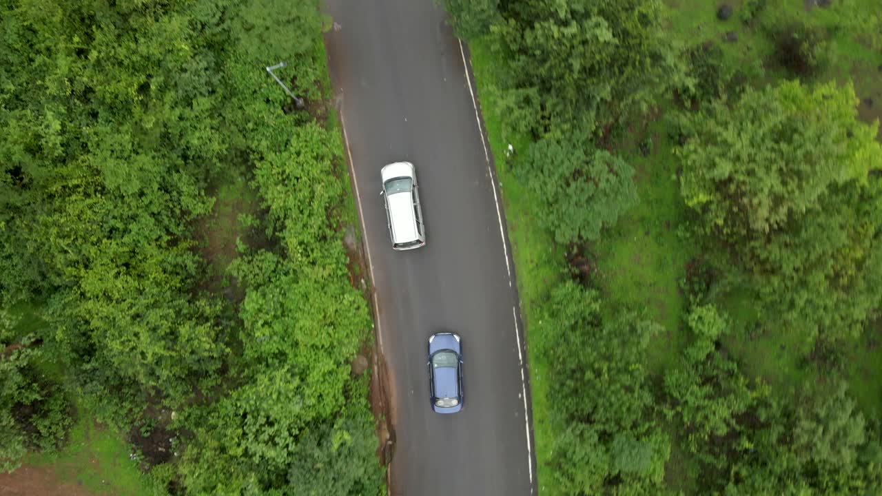 lonavla city hill station dron shot following car top view birds eye view in rainy day city 