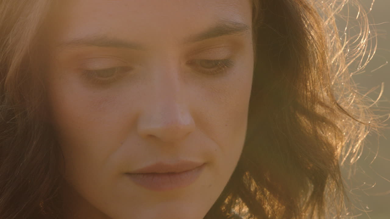 retrato en primer plano de una mujer hermosa disfrutando de una tranquila puesta de sol explorando la espiritualidad mirando hacia arriba orando contemplando el viaje con el viento soplando el cabello