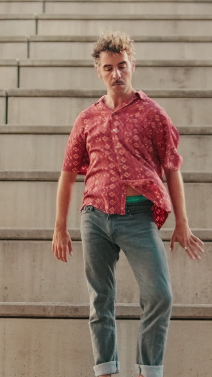 Young Man with Mustache Dancing Expressively on Concrete Steps