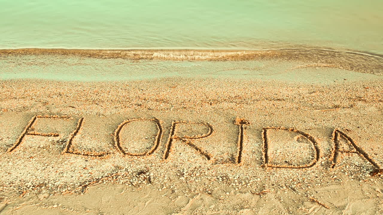 Kumda Florida yazısı. Plajda kum üzerine yazılmış yazı.