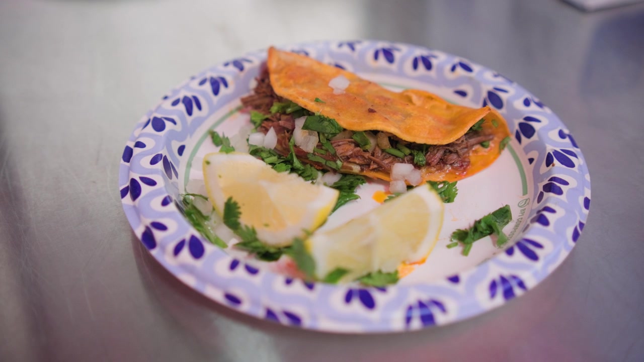 En frisklavet quesabirria taco med smeltet ost og velsmagende birria-fyld ligger på en tallerken, klar til servering