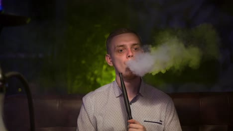 man smoking hookah in a lounge