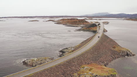 aerial view of storseisundet bridge in atlantic ocean road with cars driving in both directions, norway