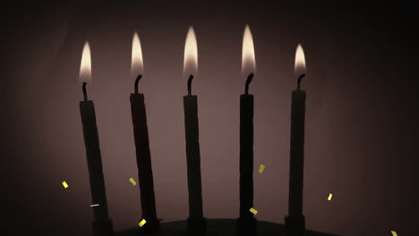 confeti dorado cayendo sobre la silueta de varias velas encendidas contra un fondo gris