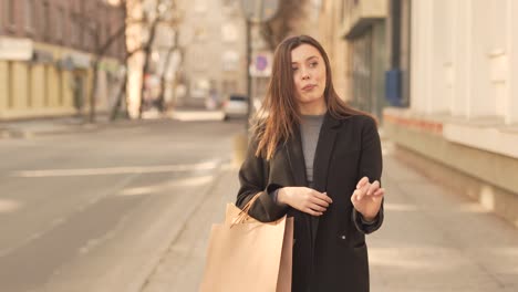 Casual-young-woman-shopper-walking-on-the-streets-with-swag,-medium-shot