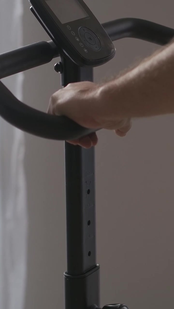 Primo piano della mano sui manubri di una cyclette durante l'allenamento