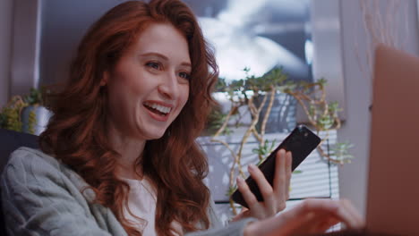 a young caucasian woman is working from home on her laptop, wins or achieves something great